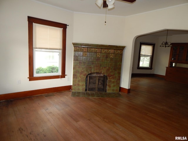 1115 W Locust St, Davenport, IA 52804 - unfurnished living room featuring a ceiling fan, hardwood / wood-style flooring, baseboards, a tiled fireplace, and ornamental molding