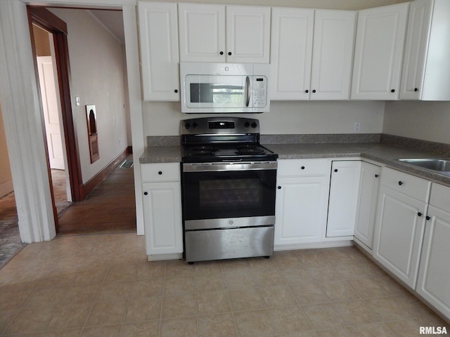 1115 W Locust St, Davenport, IA 52804 - kitchen with stainless steel range with electric stovetop, white microwave, and white cabinetry