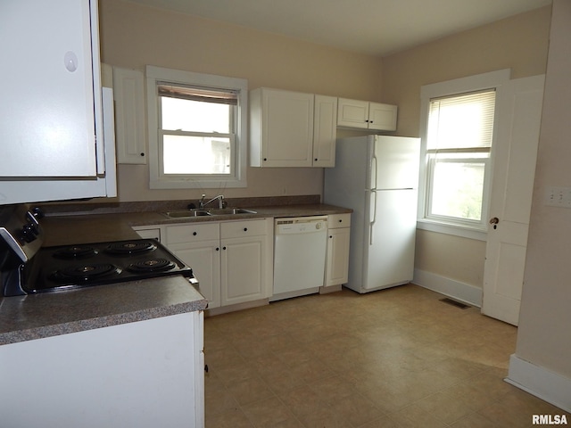 1115 W Locust St, Davenport, IA 52804 - kitchen with white appliances, a sink, healthy amount of natural light, and dark countertops