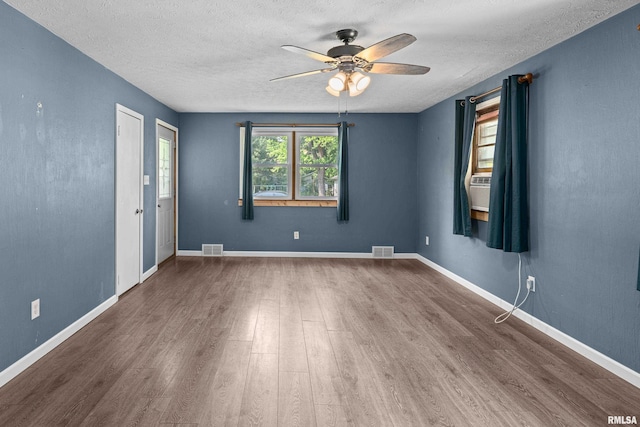 129 State St, Carbon Cliff, IL 61239 - unfurnished room featuring a ceiling fan, wood finished floors, a textured ceiling, and baseboards