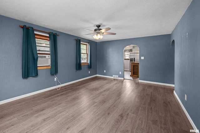 129 State St, Carbon Cliff, IL 61239 - unfurnished room featuring arched walkways, a ceiling fan, wood finished floors, a textured ceiling, and cooling unit
