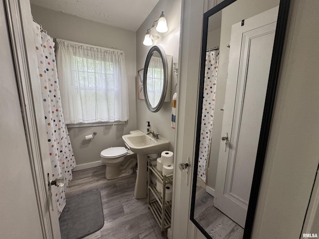 2139 10th St, East Moline, IL 61244 - full bath with toilet, wood finished floors, baseboards, a sink, and curtained shower