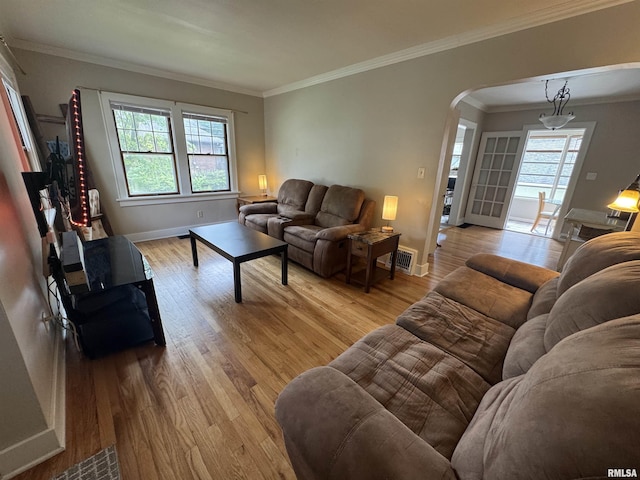 2139 10th St, East Moline, IL 61244 - living room featuring arched walkways, healthy amount of natural light, light wood-style flooring, ornamental molding, and baseboards