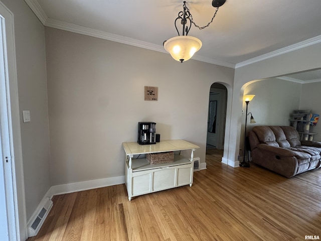 2139 10th St, East Moline, IL 61244 - living area with arched walkways, light wood-style flooring, crown molding, and baseboards