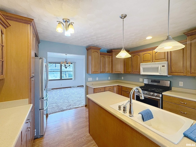 2347 W Lombard St, Davenport, IA 52804 - kitchen featuring stainless steel appliances, a chandelier, brown cabinetry, light wood-style floors, and recessed lighting