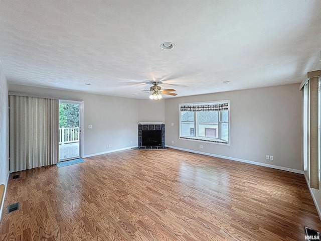 2347 W Lombard St, Davenport, IA 52804 - unfurnished living room featuring a ceiling fan, wood finished floors, a tiled fireplace, baseboards, and recessed lighting