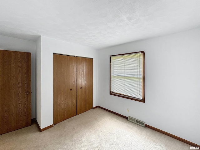 2347 W Lombard St, Davenport, IA 52804 - unfurnished bedroom featuring a closet, light colored carpet, and baseboards