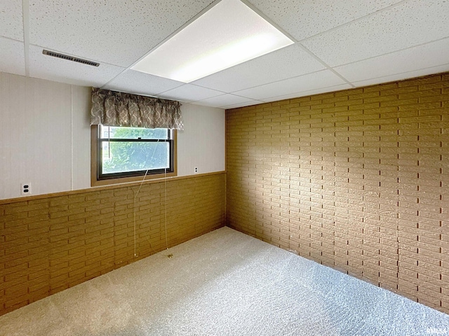 2347 W Lombard St, Davenport, IA 52804 - spare room featuring a paneled ceiling, brick wall, and carpet
