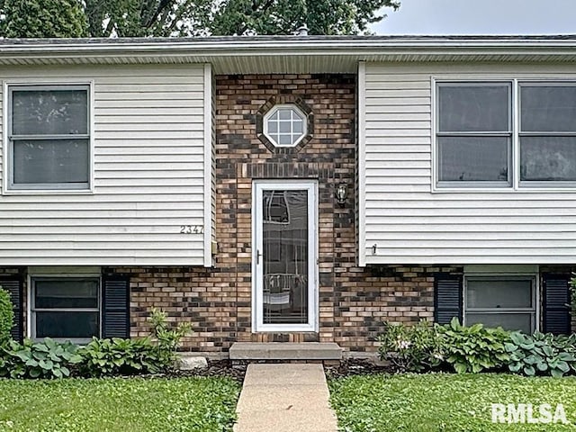 2347 W Lombard St, Davenport, IA 52804 - doorway to property with brick siding and a yard