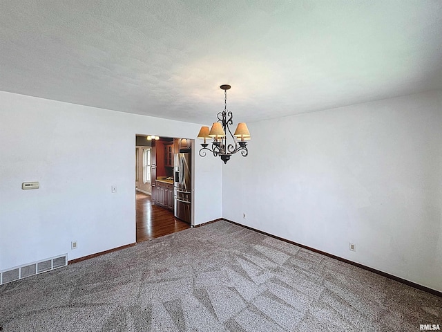 2347 W Lombard St, Davenport, IA 52804 - empty room with a chandelier, dark carpet, and baseboards