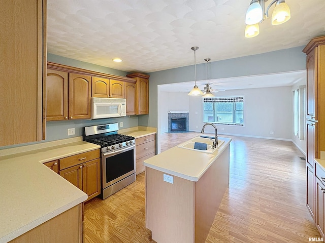 2347 W Lombard St, Davenport, IA 52804 - kitchen with gas range, white microwave, a sink, open floor plan, and an island with sink