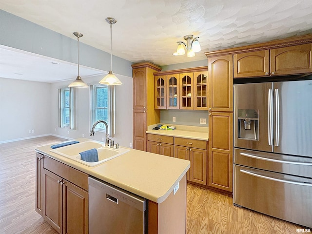 2347 W Lombard St, Davenport, IA 52804 - kitchen with stainless steel appliances, a sink, light wood-style flooring, light countertops, and brown cabinetry