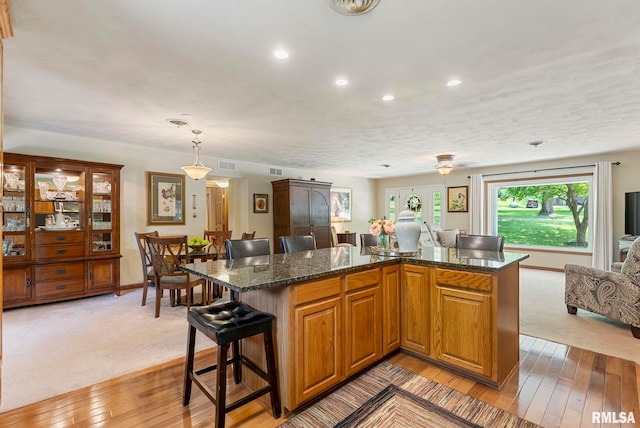 11 Shady Ln, Geneseo, IL 61254 - kitchen with a breakfast bar, light colored carpet, open floor plan, recessed lighting, and light wood-style flooring