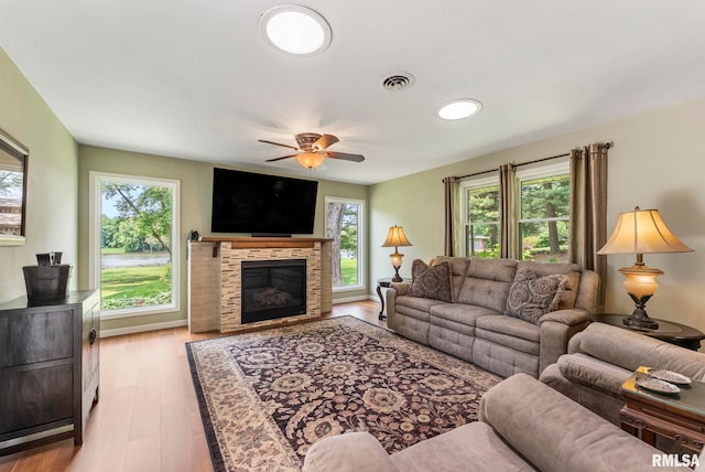 11 Shady Ln, Geneseo, IL 61254 - living room featuring healthy amount of natural light, ceiling fan, a glass covered fireplace, and wood finished floors