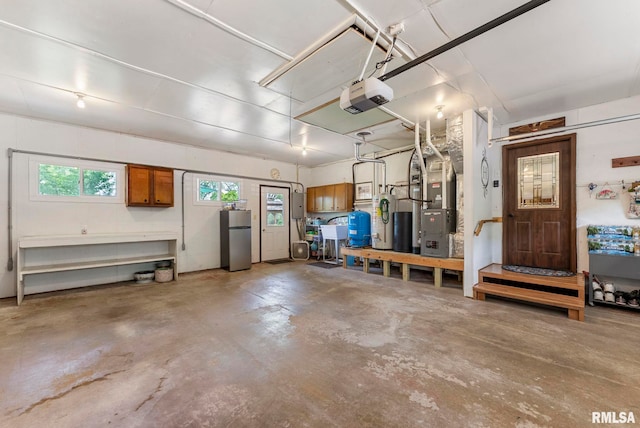 11 Shady Ln, Geneseo, IL 61254 - garage with freestanding refrigerator, a garage door opener, and heating unit