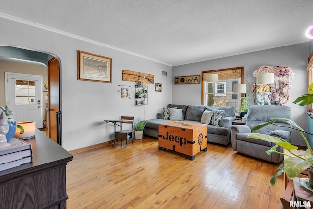 1519 W Columbia Ave, Davenport, IA 52804 - living room with arched walkways, light wood finished floors, a textured ceiling, ornamental molding, and baseboards