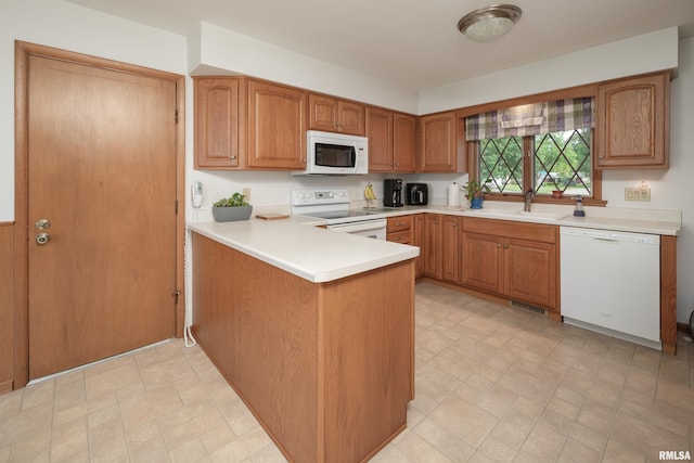 2737 28th Ave, Rock Island, IL 61201 - kitchen featuring white appliances, a sink, a peninsula, light countertops, and brown cabinets