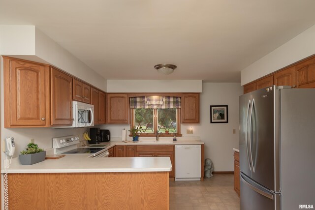 2737 28th Ave, Rock Island, IL 61201 - kitchen featuring white appliances, a sink, light countertops, a peninsula, and brown cabinetry