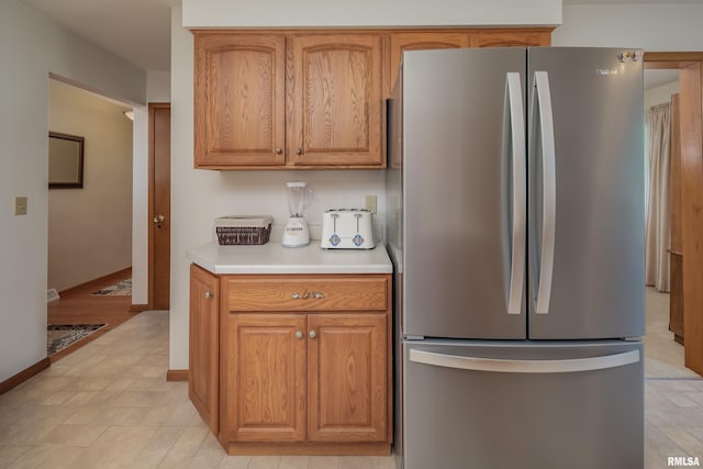 2737 28th Ave, Rock Island, IL 61201 - kitchen featuring freestanding refrigerator, light countertops, baseboards, and brown cabinets