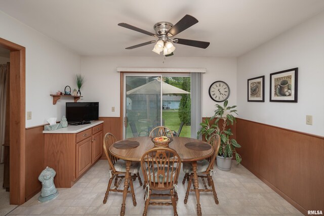 2737 28th Ave, Rock Island, IL 61201 - dining room featuring a wainscoted wall, a ceiling fan, and wooden walls