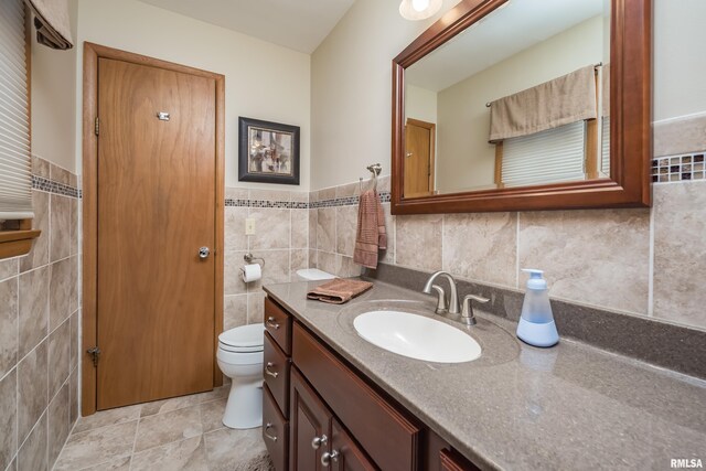 2737 28th Ave, Rock Island, IL 61201 - bathroom with tile walls, vanity, toilet, wainscoting, and tile patterned floors