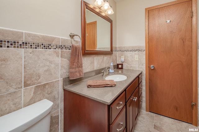 2737 28th Ave, Rock Island, IL 61201 - bathroom featuring tile walls, vanity, toilet, wainscoting, and tile patterned flooring
