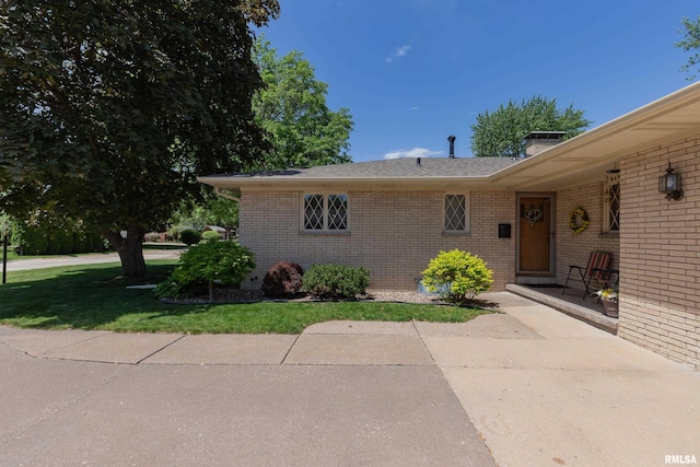 2737 28th Ave, Rock Island, IL 61201 - view of front of home with brick siding, a chimney, a front lawn, a patio, and roof with shingles