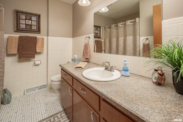 2737 28th Ave, Rock Island, IL 61201 - bathroom featuring vanity, toilet, tile walls, tile patterned flooring, and wainscoting