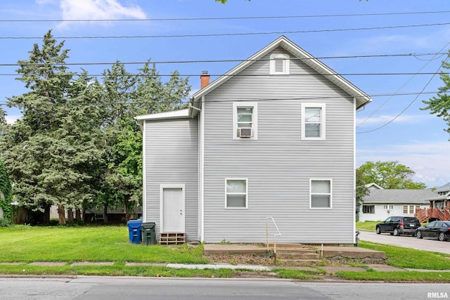2734 Bridge Ave, Davenport, IA 52803 - view of home's exterior with a chimney, a lawn, and cooling unit
