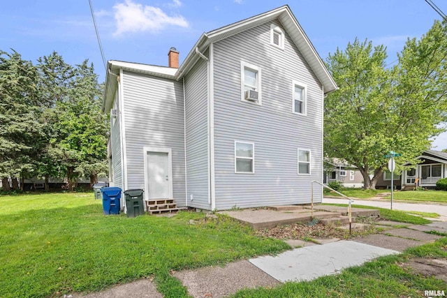 2734 Bridge Ave, Davenport, IA 52803 - view of home's exterior featuring entry steps, a chimney, a yard, and cooling unit