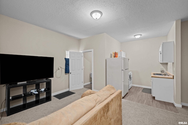 2734 Bridge Ave, Davenport, IA 52803 - living area with light carpet, baseboards, and a textured ceiling