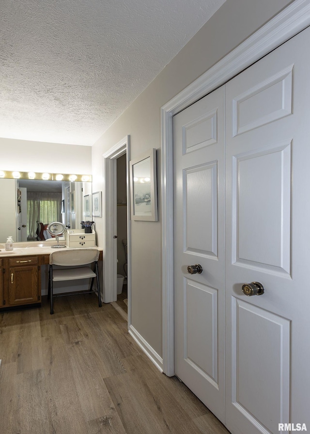 726 51st Ave Unit 20, East Moline, IL 61244 - bathroom with wood finished floors, double vanity, a textured ceiling, and toilet