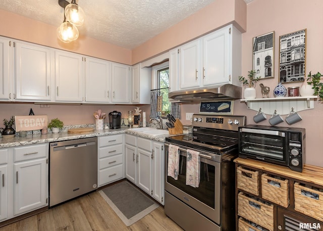 726 51st Ave Unit 20, East Moline, IL 61244 - kitchen featuring appliances with stainless steel finishes, a sink, under cabinet range hood, white cabinets, and a textured ceiling