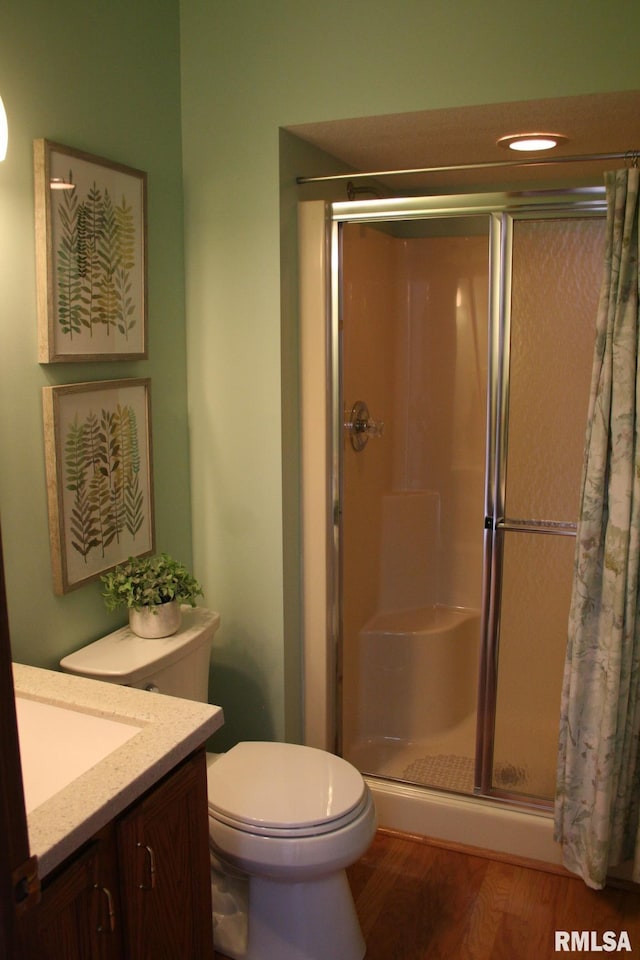 3996 Partridge Cir, Bettendorf, IA 52722 - bathroom with a shower stall, toilet, wood finished floors, and vanity