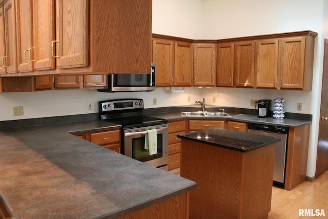 3996 Partridge Cir, Bettendorf, IA 52722 - kitchen with stainless steel appliances, a sink, dark countertops, and brown cabinetry