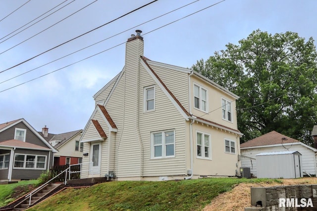 1617 Payson Ave, Quincy, IL 62301 - view of home's exterior with a sunroom, a chimney, and central AC unit