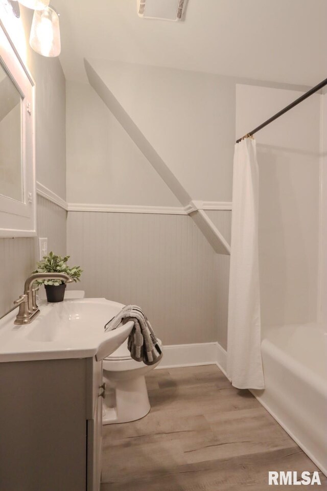 1617 Payson Ave, Quincy, IL 62301 - bathroom with vanity, a wainscoted wall, shower / tub combo, wood finished floors, and toilet