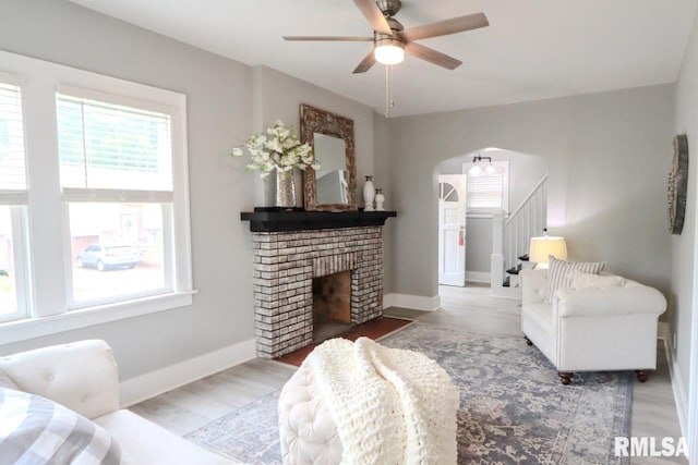 1617 Payson Ave, Quincy, IL 62301 - living area with ceiling fan, arched walkways, stairway, a brick fireplace, and baseboards