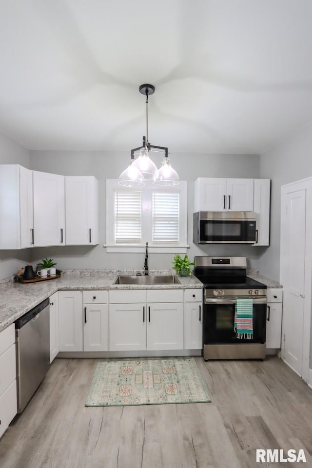 1617 Payson Ave, Quincy, IL 62301 - kitchen featuring appliances with stainless steel finishes, a sink, white cabinetry, and light wood finished floors