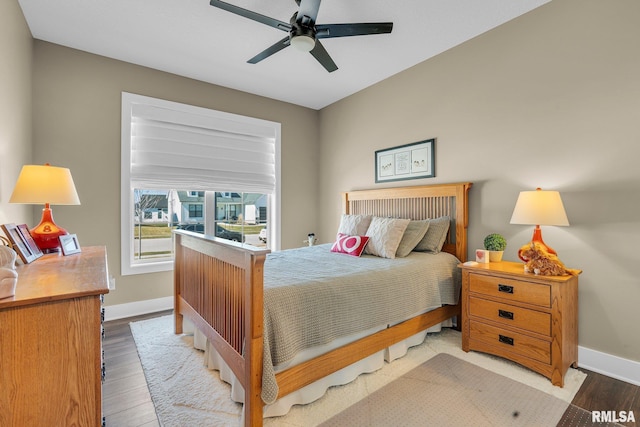 6997 Matthews Pass, Bettendorf, IA 52722 - bedroom featuring baseboards, wood finished floors, and a ceiling fan