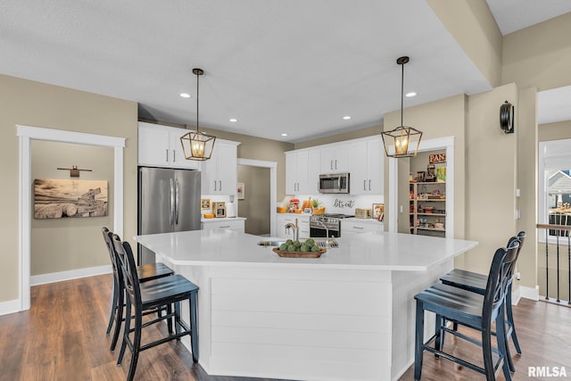 6997 Matthews Pass, Bettendorf, IA 52722 - kitchen with appliances with stainless steel finishes, light countertops, dark wood-style flooring, white cabinetry, and recessed lighting