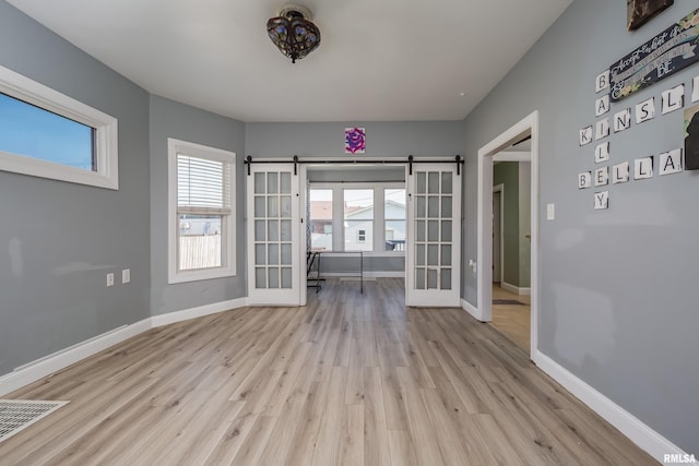 1637 24th Ave, Moline, IL 61265 - spare room with a barn door, wood finished floors, and baseboards