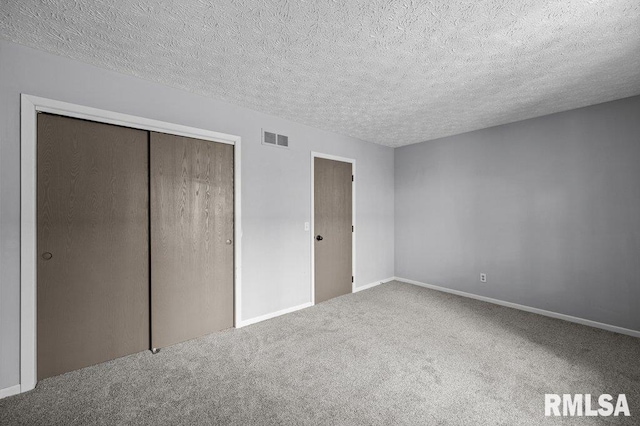 4015 Lillie Ave Unit 106, Davenport, IA 52806 - unfurnished bedroom with carpet, a closet, a textured ceiling, and baseboards