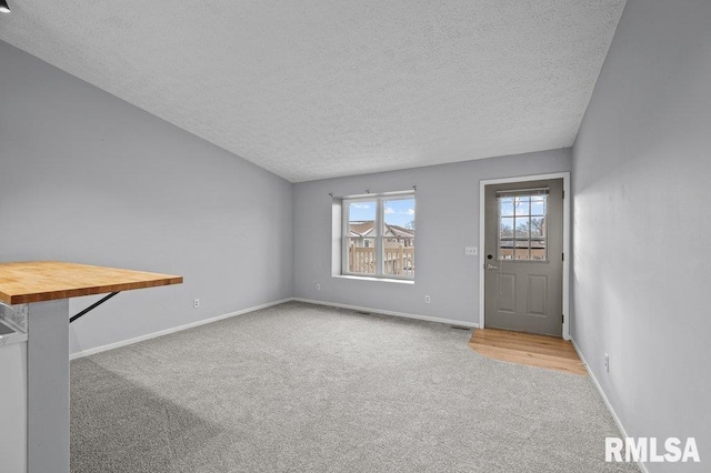 4015 Lillie Ave Unit 106, Davenport, IA 52806 - unfurnished living room with carpet flooring, a textured ceiling, and baseboards