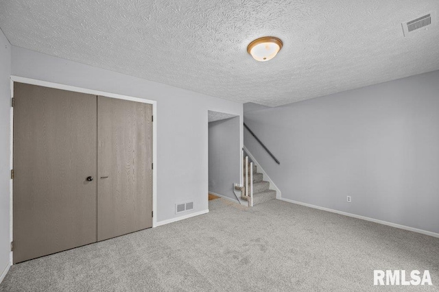 4015 Lillie Ave Unit 106, Davenport, IA 52806 - below grade area with carpet flooring, stairway, baseboards, and a textured ceiling