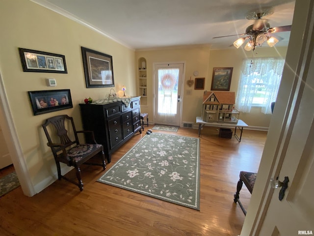 904 W Main St, Reynolds, IL 61279 - foyer entrance featuring ornamental molding, wood finished floors, a ceiling fan, arched walkways, and baseboards