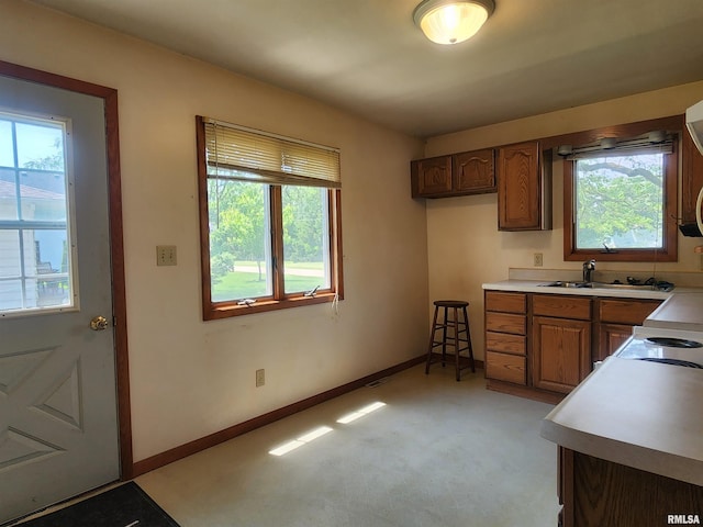 119 9th Ave, Camanche, IA 52730 - kitchen with healthy amount of natural light, light countertops, and brown cabinetry