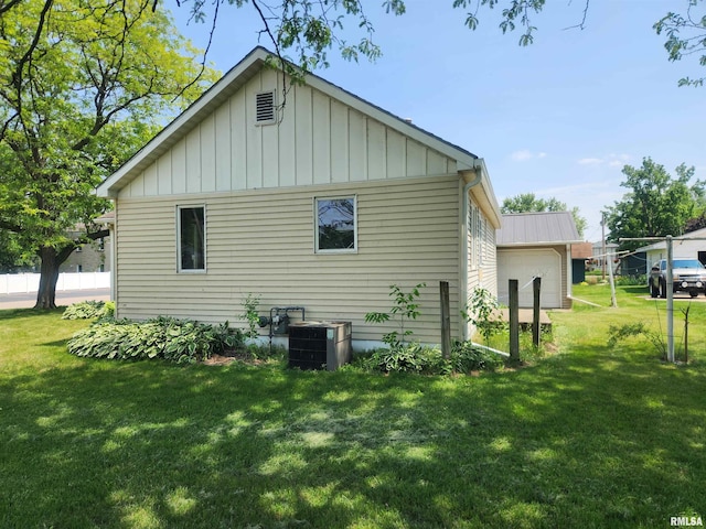 119 9th Ave, Camanche, IA 52730 - rear view of house featuring board and batten siding, central AC unit, and a lawn
