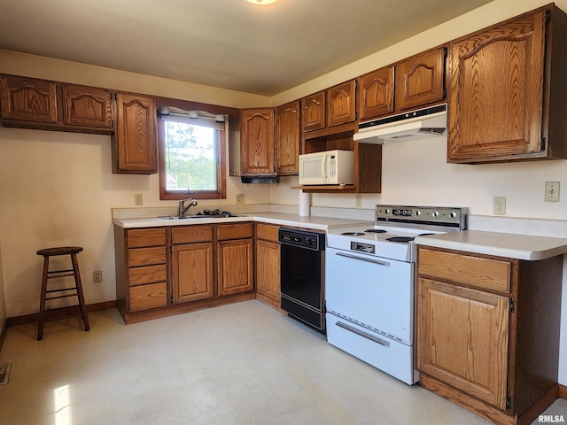 119 9th Ave, Camanche, IA 52730 - kitchen with under cabinet range hood, white appliances, a sink, and brown cabinetry