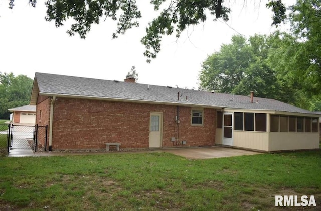 2034 W Wilmar Dr, Quincy, IL 62301 - rear view of house with a patio area, brick siding, a sunroom, a gate, and a chimney